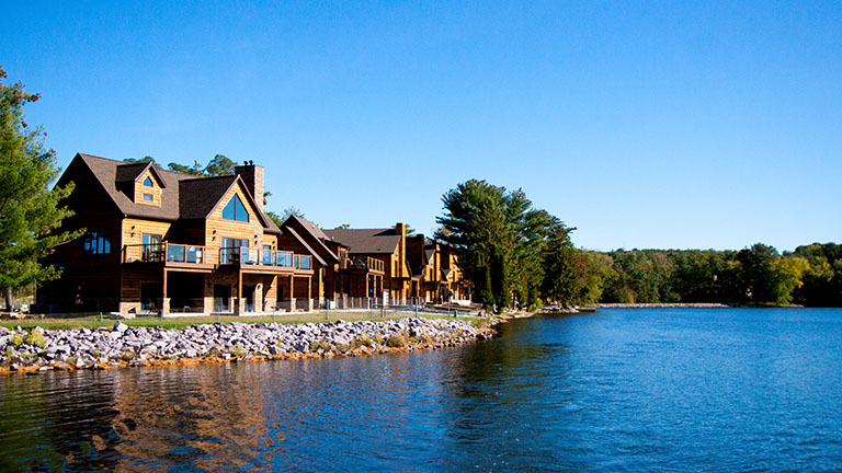 multiple log cabins next to the lake